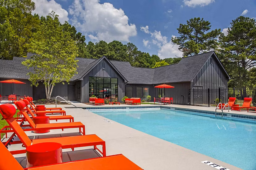 Modern pool with sun loungers at The Oakley Apartments, offering luxury living and relaxation amenities