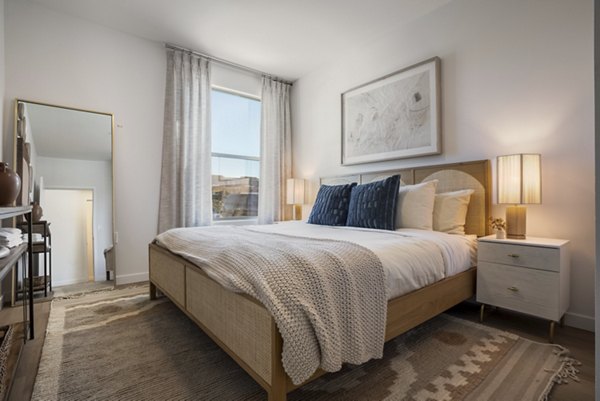 Modern bedroom with elegant decor and ample natural light at Encanto at Mesa Del Sol Apartments