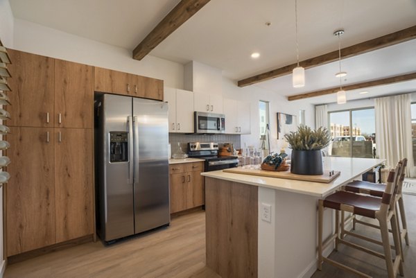 Modern kitchen with stainless steel appliances in Encanto at Mesa Del Sol Apartments