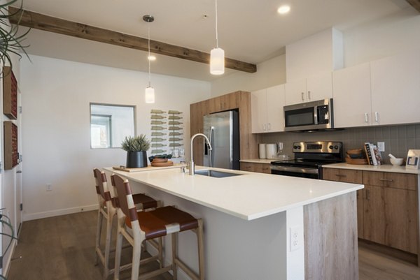 Modern kitchen with stainless steel appliances at Encanto at Mesa Del Sol Apartments