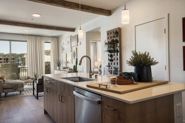 Modern kitchen with stainless steel appliances at Encanto at Mesa Del Sol Apartments