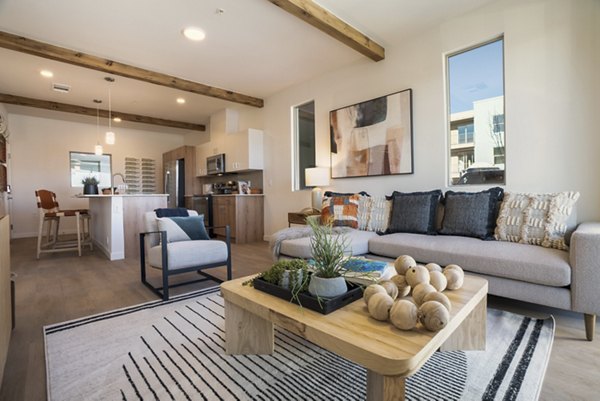 Living room featuring modern decor and large windows at Encanto at Mesa Del Sol Apartments