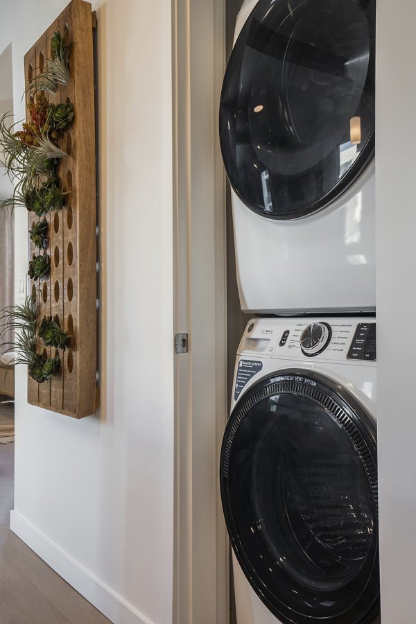 Laundry room with energy-efficient washer and dryer at Encanto at Mesa Del Sol Apartments