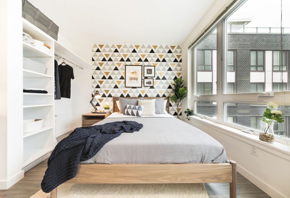 Bedroom featuring elegant decor and large windows at The Parsonage Apartments