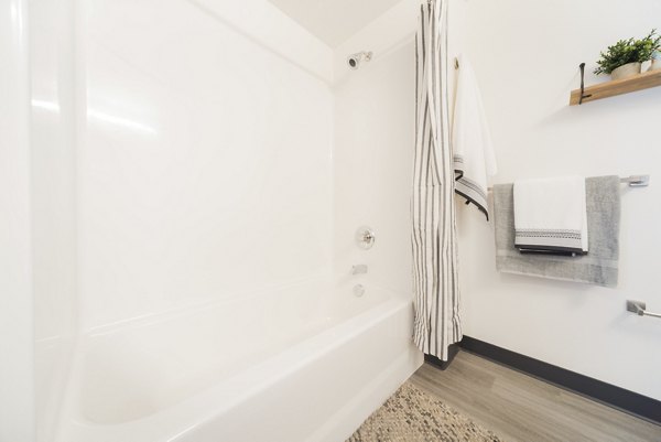 Bathroom featuring elegant marble tile and modern fixtures at The Parsonage Apartments