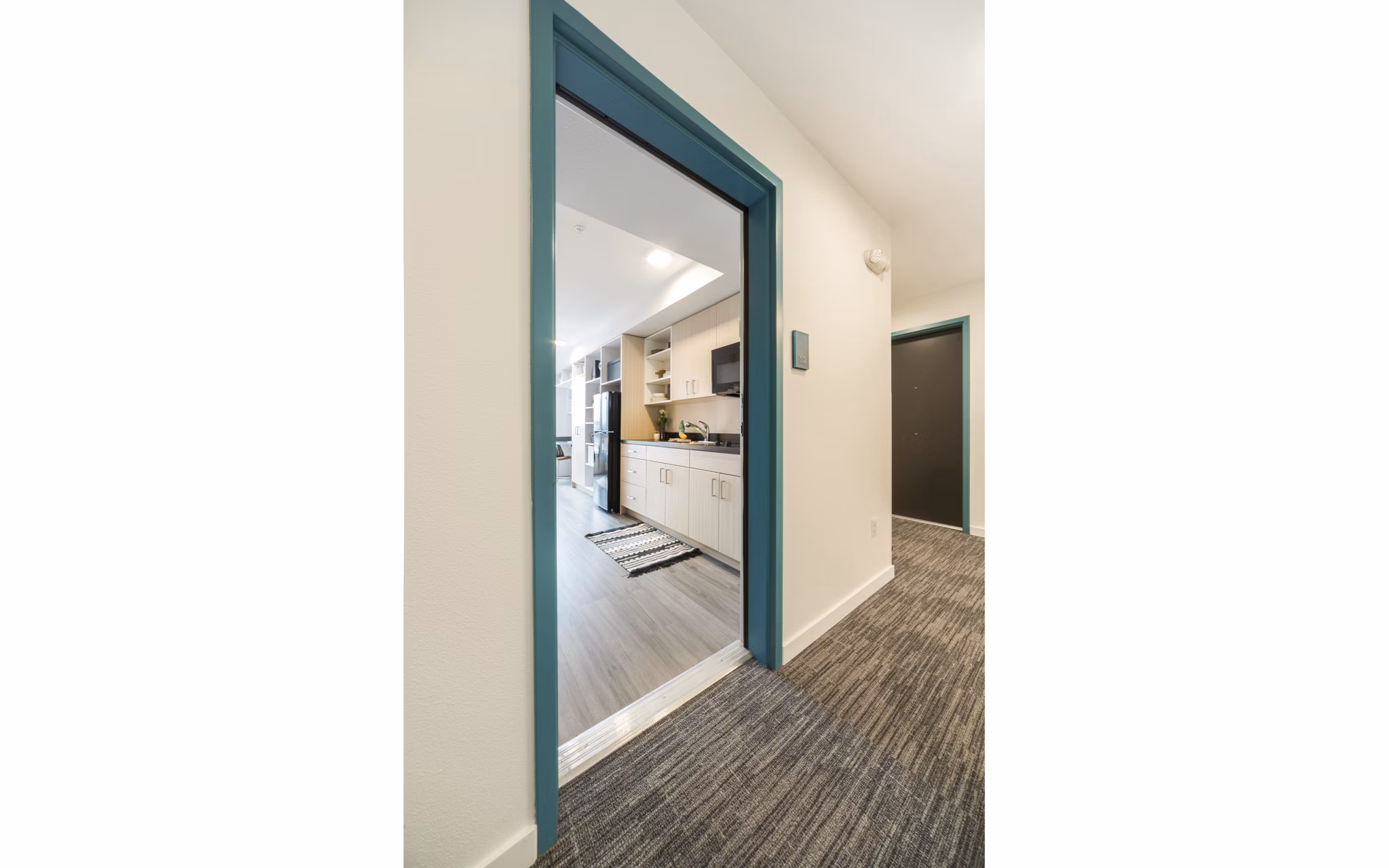 Elegant hallway featuring modern lighting and sleek flooring at The Parsonage Apartments