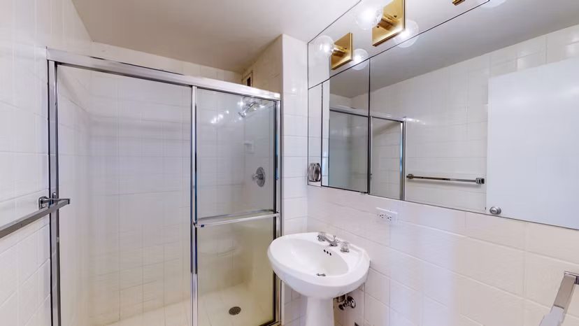 Elegant bathroom with marble countertops and modern fixtures in 1000 Chestnut Apartments