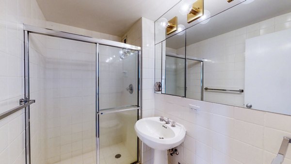 Elegant bathroom with marble countertops and modern fixtures in 1000 Chestnut Apartments