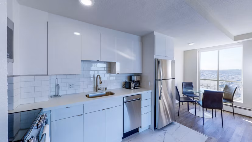 Stylish kitchen with stainless steel appliances and granite countertops in 1000 Chestnut Apartments