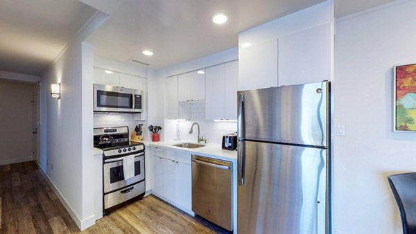 Kitchen with modern appliances and granite countertops at 1000 Chestnut Apartments