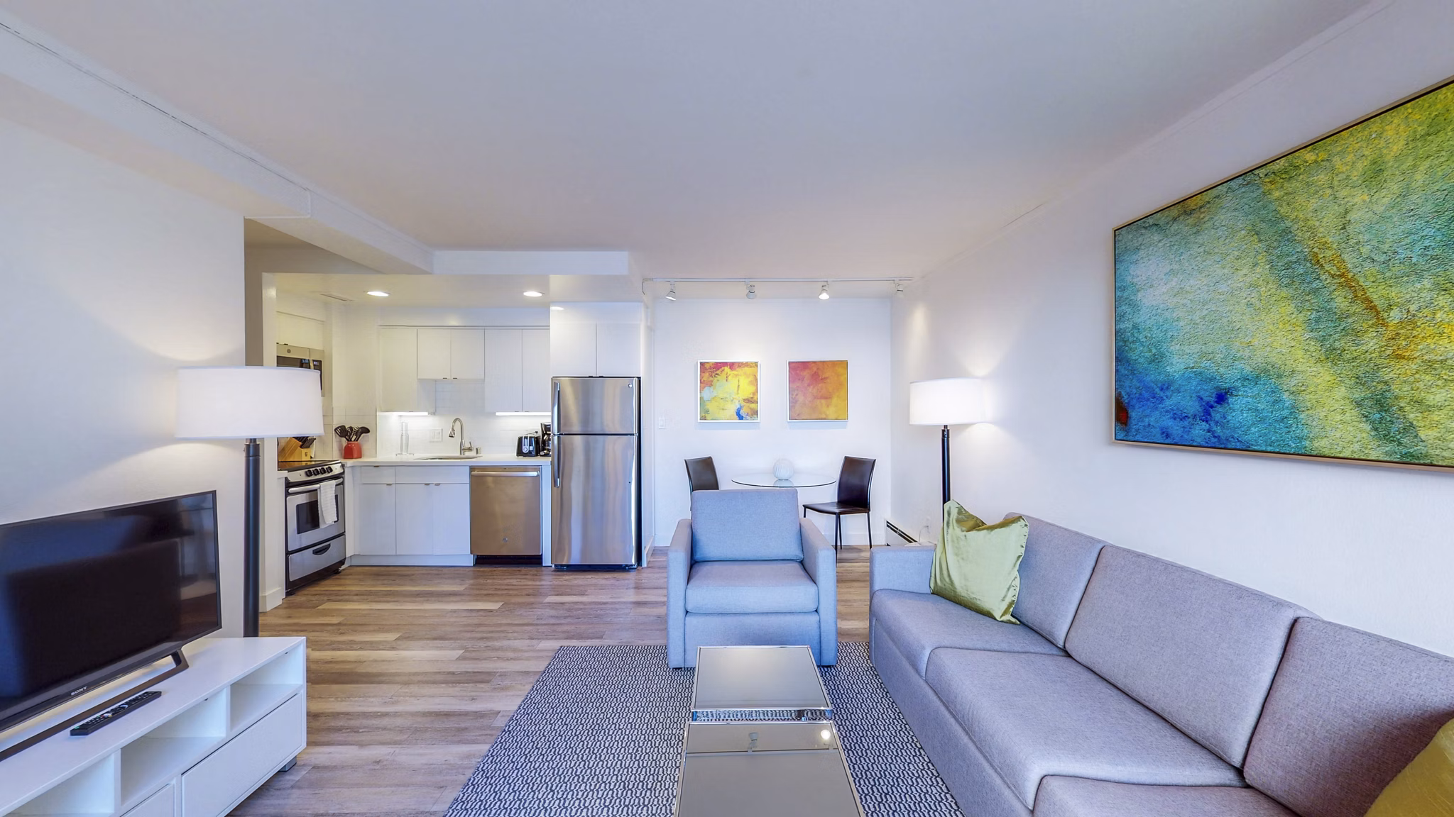 Spacious living room with modern furnishings at 1000 Chestnut Apartments, featuring large windows and elegant decor