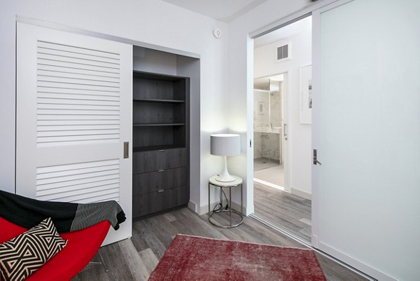 Bedroom with home office nook at 1177 Market Apartments, featuring modern decor and ample natural light