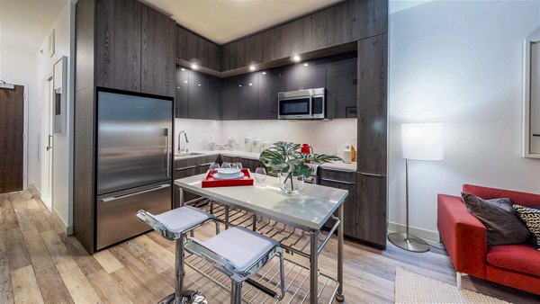 Modern kitchen and dining room with sleek countertops at 1177 Market Apartments, showcasing luxurious urban living