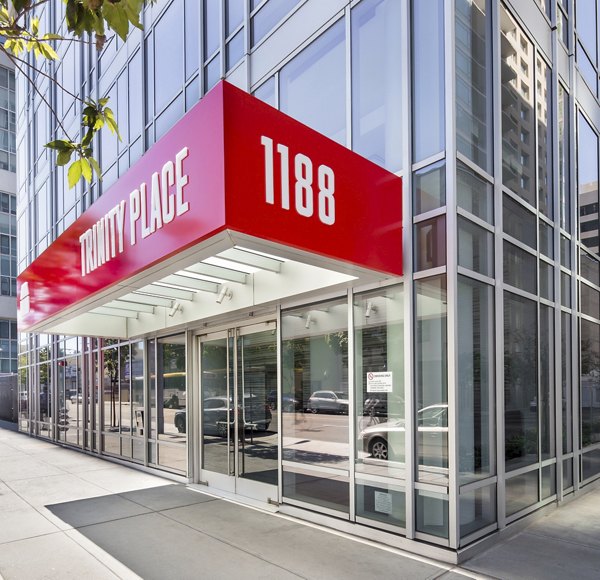 Trinity Place entrance with a red awning displaying TRINITY PLACE and the number 1188 in a luxury apartment setting