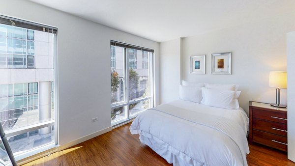 Bedroom featuring modern furnishings and city views at 1188 Mission Apartments