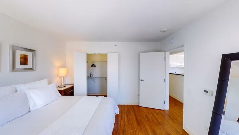 Bedroom featuring modern design with cozy bedding and large windows in 1188 Mission Apartments