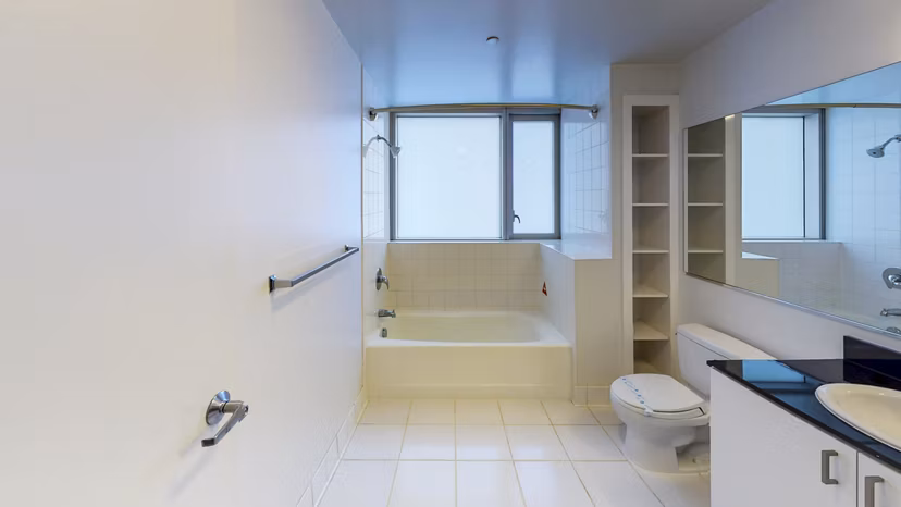 Modern bathroom with marble countertops and glass shower at 1188 Mission Apartments