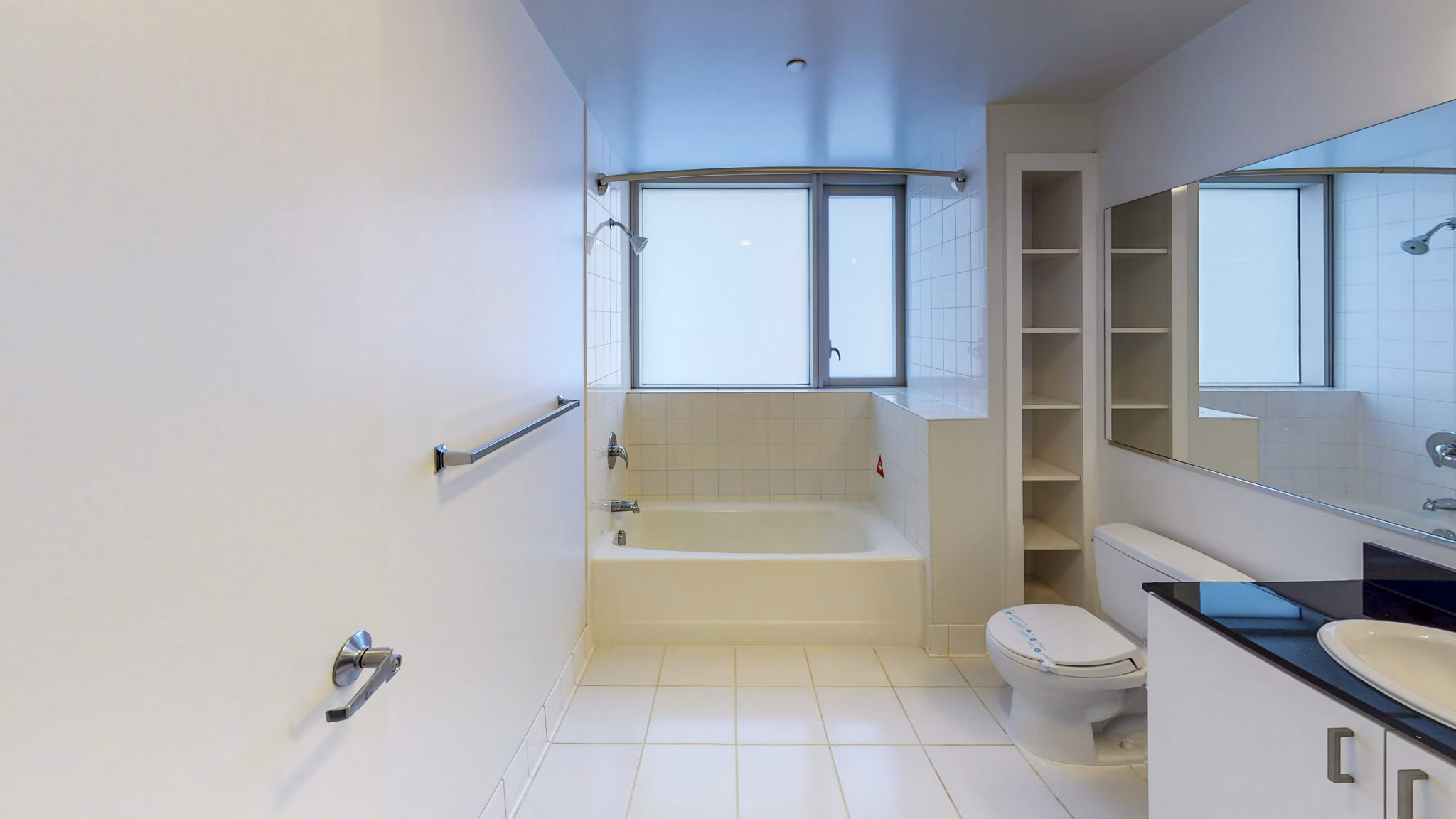 Modern bathroom with marble countertops and glass shower at 1188 Mission Apartments