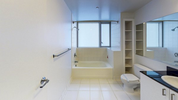 Modern bathroom with marble countertops and glass shower at 1188 Mission Apartments