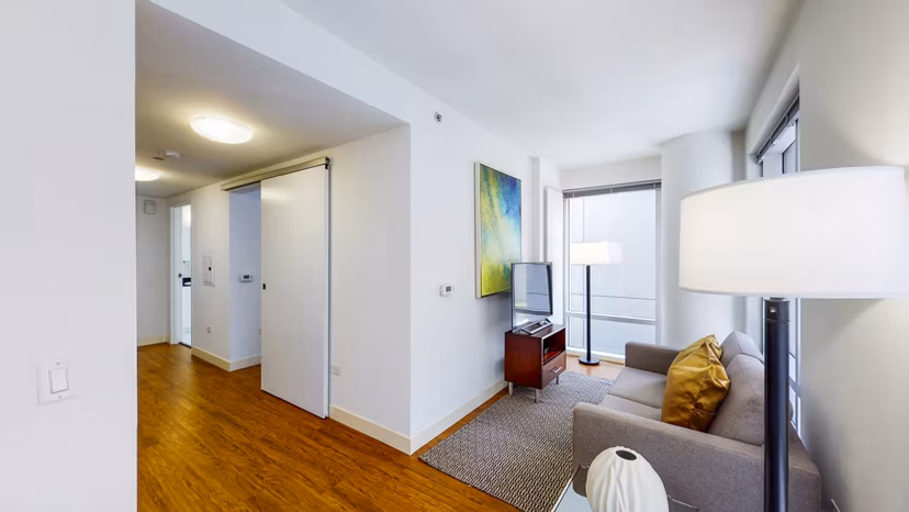 Living room with modern decor and floor-to-ceiling windows at 1188 Mission Apartments in San Francisco