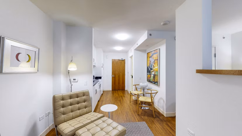 Spacious living room featuring modern decor and large windows at 1188 Mission Apartments