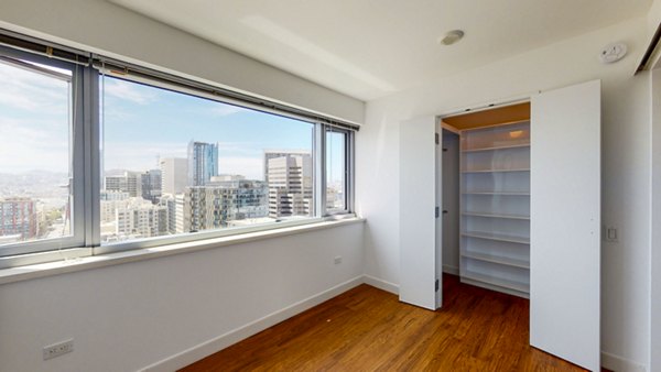 Cozy bedroom with large window and modern decor at 1190 Mission Apartments