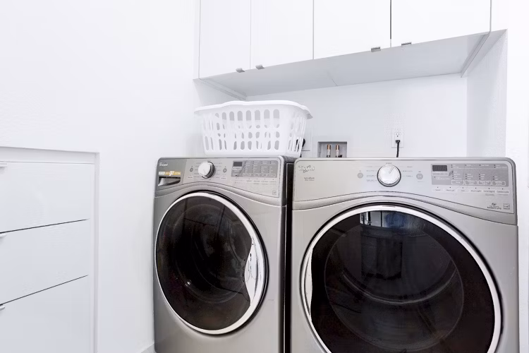 Laundry room featuring modern washers and dryers at 2000 Broadway Apartments in luxury Greystar community