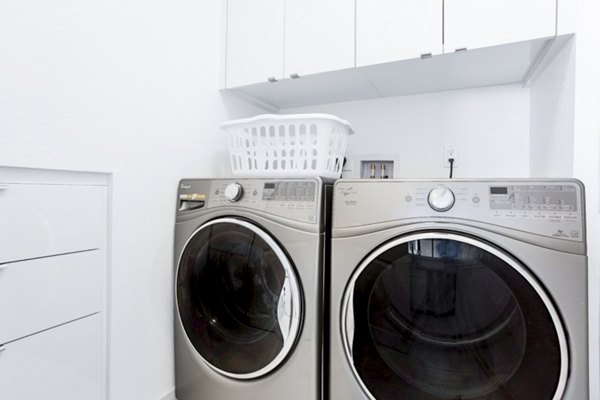 Laundry room featuring modern washers and dryers at 2000 Broadway Apartments in luxury Greystar community