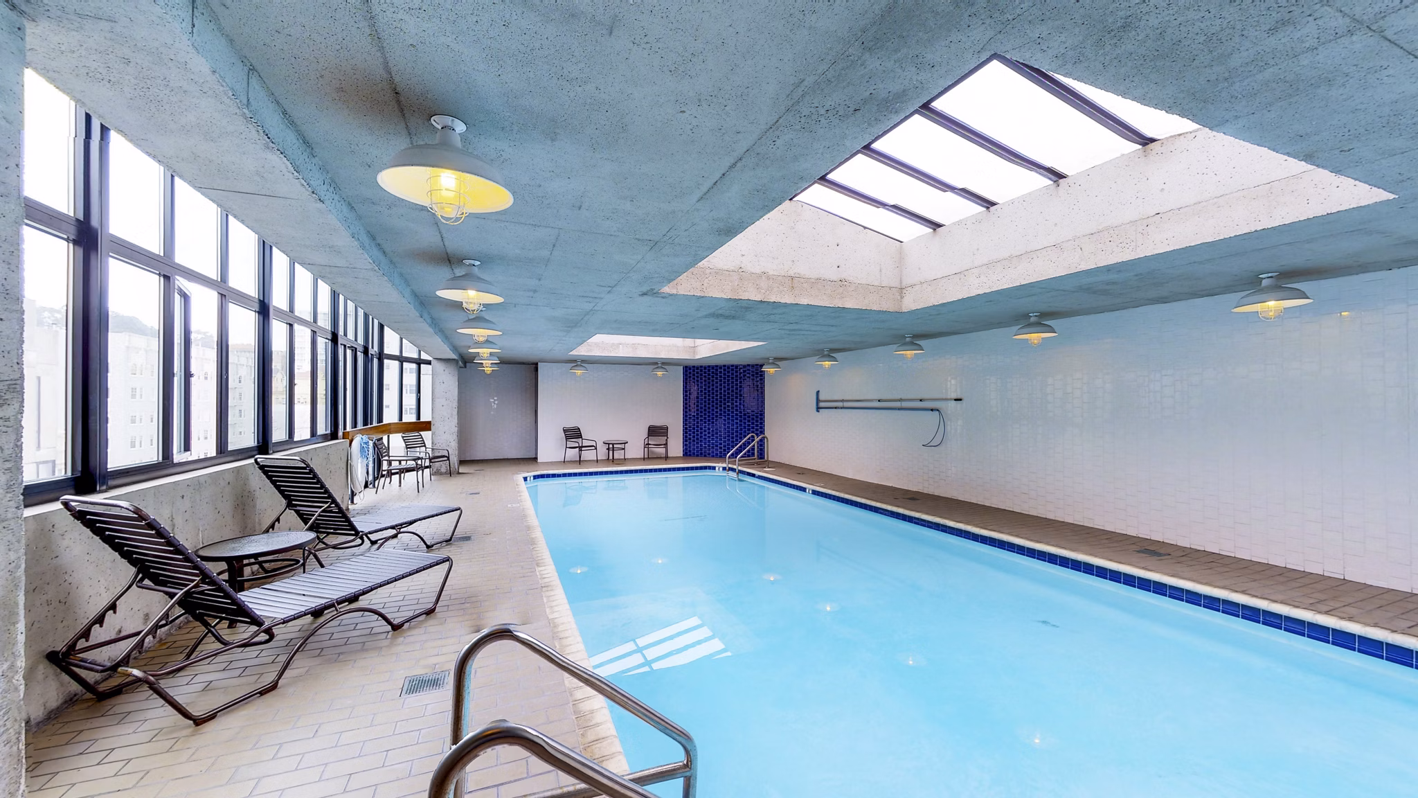 Outdoor pool with lounge chairs at 2000 Broadway Apartments offers a luxurious retreat for residents seeking leisure and relaxation