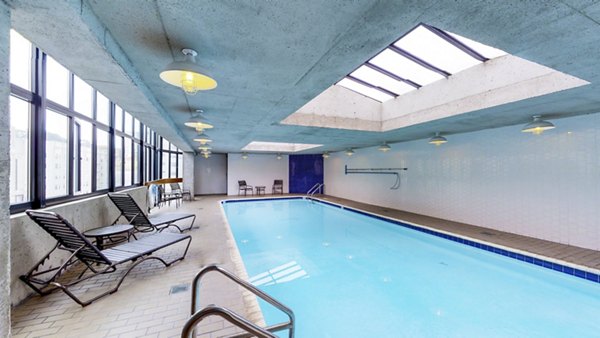 Outdoor pool with lounge chairs at 2000 Broadway Apartments offers a luxurious retreat for residents seeking leisure and relaxation