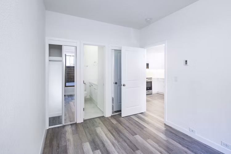 Elegant bedroom with a designer touch at 2133 Stockton Apartments, featuring sleek furnishings and warm lighting for a luxurious living experience