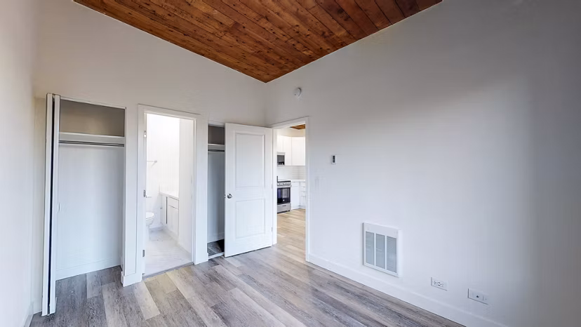 Cozy bedroom with natural lighting at 2133 Stockton Apartments featuring stylish decor and modern furnishings