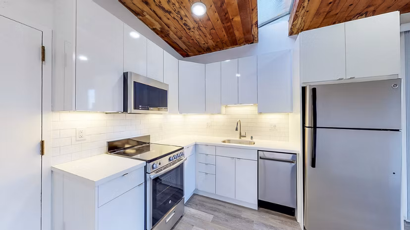 â€œModern kitchen with granite countertops in 2133 Stockton Apartments, luxury living in a prime urban locationâ€