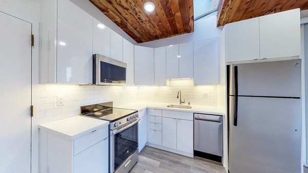 â€œModern kitchen with granite countertops in 2133 Stockton Apartments, luxury living in a prime urban locationâ€