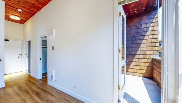 Living room with contemporary furnishings and large windows at 2133 Stockton Apartments