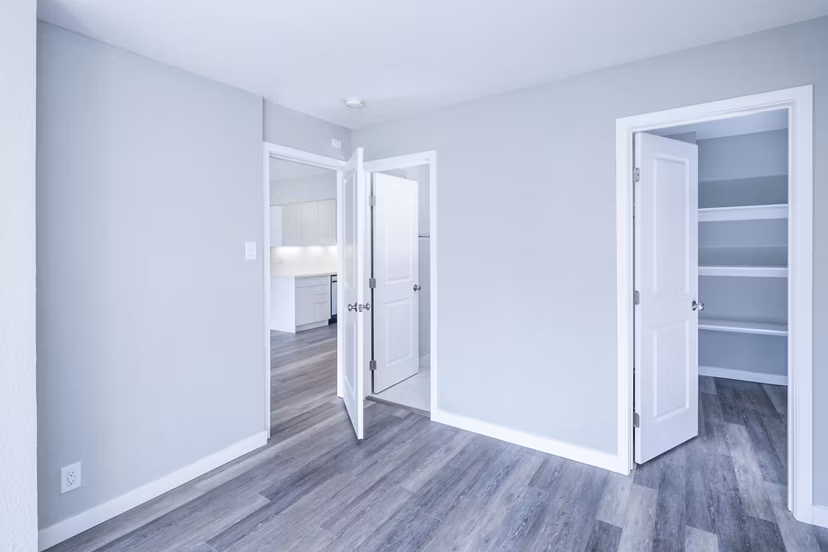Bedroom with modern furnishings and large windows in 230 Dolores Apartments