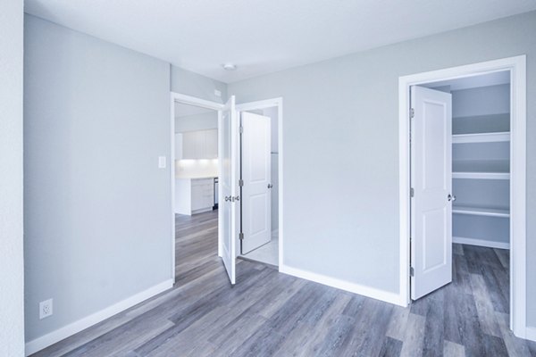 Bedroom with modern furnishings and large windows in 230 Dolores Apartments