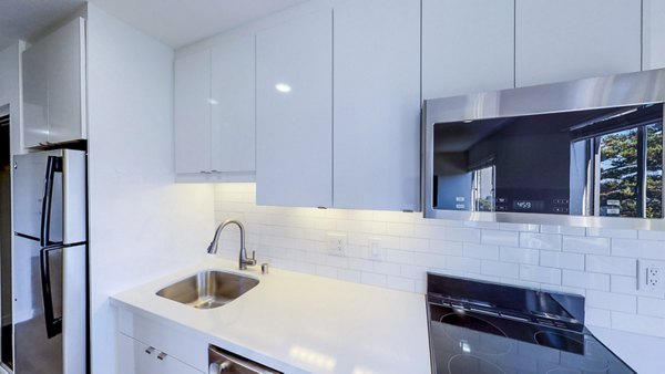 Modern kitchen with stainless steel appliances and granite countertops at 230 Dolores Apartments