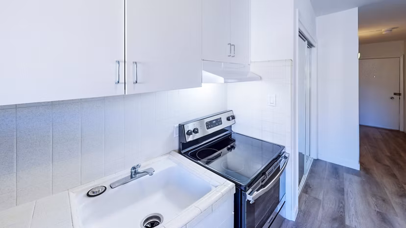 Modern kitchen with stainless steel appliances and quartz countertops at 230 Dolores Apartments, luxury living in San Francisco