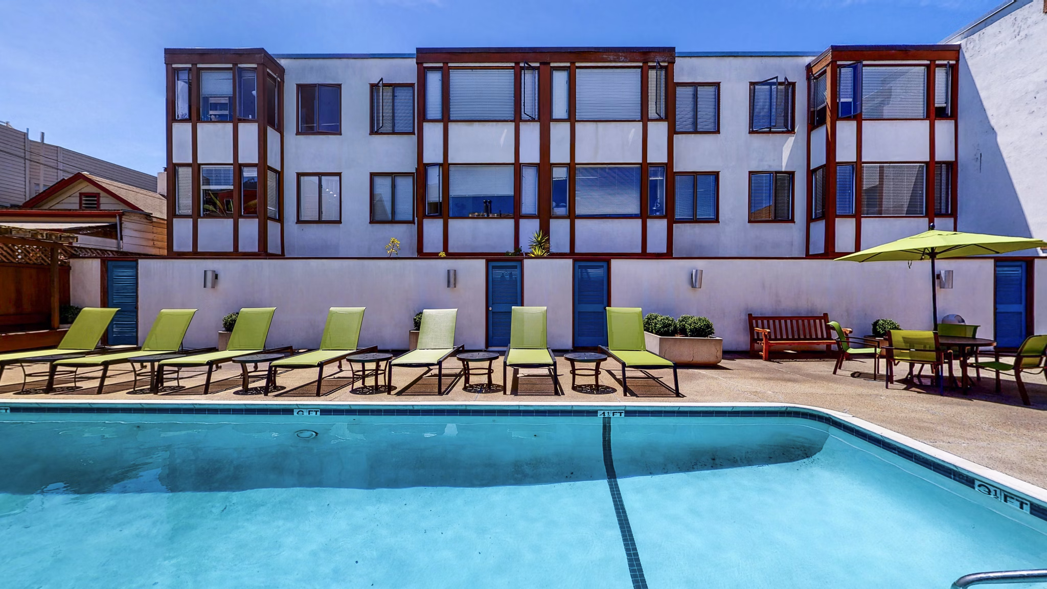 Chic outdoor pool area at 230 Dolores Apartments featuring spacious lounge seating and landscaped surroundings for relaxation