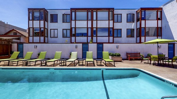 Chic outdoor pool area at 230 Dolores Apartments featuring spacious lounge seating and landscaped surroundings for relaxation