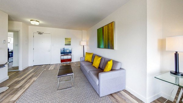 Modern living room featuring a gray sofa and vibrant yellow pillows in luxury apartments