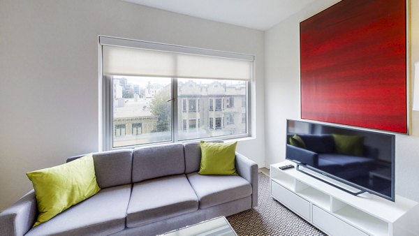Spacious living room with modern decor and large windows at Clay Park Tower Apartments