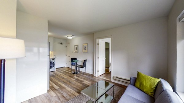 Spacious living room with elegant decor and large windows at Clay Park Tower Apartments