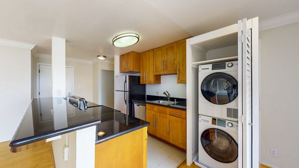 Modern kitchen and laundry room with stainless steel appliances at Clay Park Tower Apartments