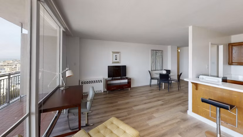 Living room with modern decor and large windows at Crystal Tower Apartments, a luxury Greystar property
