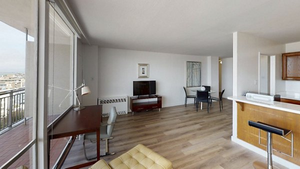 Living room with modern decor and large windows at Crystal Tower Apartments, a luxury Greystar property