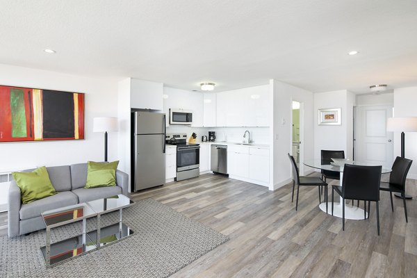 Comfortable living room with modern decor and ample natural light at Crystal Tower Apartments