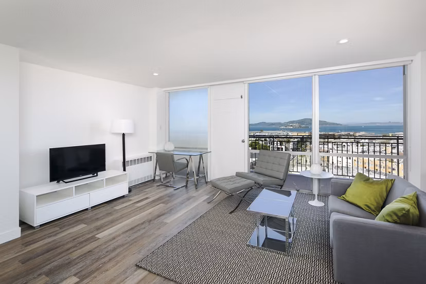 Spacious living room with elegant decor at Crystal Tower Apartments, featuring floor-to-ceiling windows and contemporary furniture