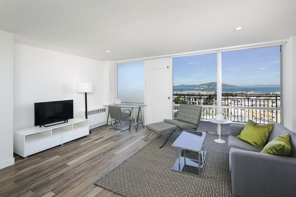 Spacious living room with elegant decor at Crystal Tower Apartments, featuring floor-to-ceiling windows and contemporary furniture